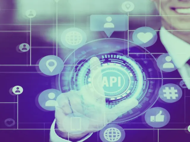 Homem vestido com terno formal sorrindo levemente enquanto toca com o dedo indicador em uma interface digital futurista projetada no ar. O foco da imagem é um círculo brilhante sob o dedo dele com a sigla 'API' no centro. Ao redor, uma rede de linhas conecta diversos ícones de tecnologia e interação social, como localização, perfis de usuário, hashtags, globo terrestre e corações, tudo em tons vibrantes de azul e roxo.